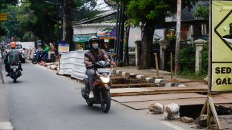 Pengendara melintas disamping proyek galian saluran di Pejaten, Pasar Minggu, Jakarta Selatan, Selasa (18/10/2022). [Suara.com/Alfian Winanto]