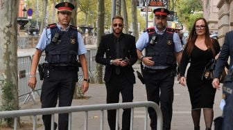 Pesepak bola Paris Saint-Germain Neymar (tengah) pergi bersama ibunya Nadine Goncalves da Silva Santos (kanan) menghadiri sidang di gedung pengadilan di Barcelona, Spanyol, Senin (17/10/2022). [Pau BARRENA / AFP]
