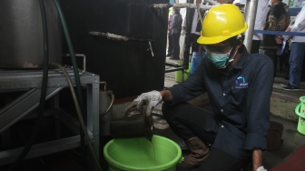 Petugas mengumpulkan bensin dari sampah plastik di IPST Asari, Kotabumi Kecamatan Purwakarta, Kota Cilegon, Banten, Rabu (19/10). [Suara.com/Oke Atmaja]. 