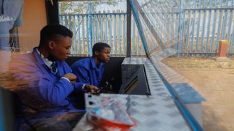 Siswa sekolah menengah teknik Soshanguve mengerjakan kereta bertenaga surya yang mereka buat, di kotapraja Soshanguve, Pretoria, Afrika Selatan, Selasa (20/10/2022). [Phill Magakoe / AFP]
