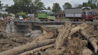 Sejumlah truk dan kendaraan melintasi jembatan yang rusak pascabanjir bandang di lingkungan Bilukpoh, Kelurahan Tegal Cangkring, Jembrana, Bali, Jumat (21/10/2022). [ANTARA FOTO/Nyoman Hendra Wibowo/nz]