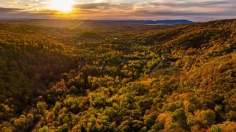 Gambar udara menunjukkan Danau Baker yang dikelilingi oleh pepohonan dengan warna musim gugur di East Bolton, Quebec, Kanada, Sabtu (8/10/2022). [Sebastien ST-JEAN / AFP]