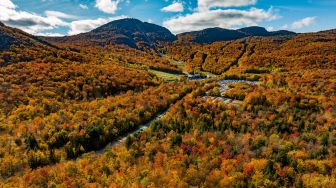 Gambar udara menunjukkan Taman Nasional Mont-Orford yang dikelilingi oleh pepohonan dengan warna musim gugur di Quebec, Kanada, Sabtu (8/10/2022). [Sebastien ST-JEAN / AFP]
