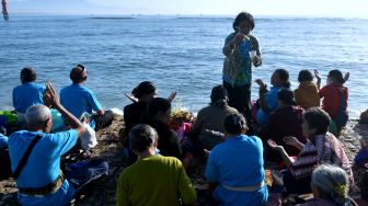 Sejumlah umat Hindu berendam di air saat melakukan ritual Melukat atau menyucikan diri pada Hari Banyu Pinaruh di Pantai Sanur, Denpasar, Bali, Minggu (23/10/2022). [ANTARA FOTO/Fikri Yusuf/tom]