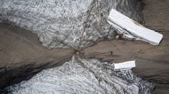 Foto udara menunjukkan selimut yang menutupi es di celah Tsanfleuron untuk mencegahnya mencair di resor Glacier, Les Diablerets, Swiss, Selasa (13/9/2022). [Fabrice COFFRINI / AFP]
