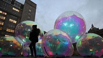 Sebuah karya seni berjudul "Evanescent" oleh studio desain Atelier Sisu dipamerkan saat festival River of light di Liverpool, Inggris, Kamis (20/10/2022). [Paul ELLIS / AFP]