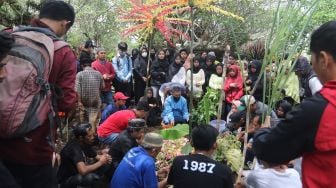 Warga dan suporter Aremania berdoa di makam almarhum Farzah Dwi Kurniawan untuk dimakamkan di Tempat Pemakaman Umum (TPU) Sudimoro, Malang, Jawa Timur, Senin (24/10/2022). Farzah merupakan korban meninggal dunia dari tragedi Kanjuruhan yang ke-135 setelah sebelumnya sempat dirawat di rumah sakit sejak 1 Oktober 2022. [ANTARA FOTO/Ari Bowo Sucipto/foc]