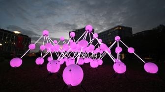 Sebuah karya seni berjudul "Affinity" oleh studio desain Amigo & Amigo dipamerkan saat festival River of light di Liverpool, Inggris, Kamis (20/10/2022). [Paul ELLIS / AFP]