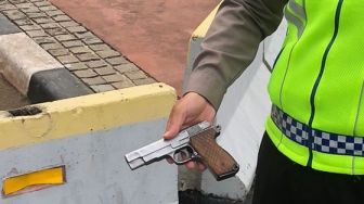 Polisi menunjukan pistol yang dibawa wanita berhijab setelah berhasil menerobos di depan Istana Merdeka, Jalan Merdeka Utara, Jakarta Pusat, Selasa (25/10/2022). [Foto dok. Polisi/ ist]