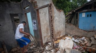 Warga membersihkan puing-puing rumah yang ambruk akibat angin kencang di Sangiang Tanjung, Lebak, Banten, Rabu (26/10/2022). [ANTARA FOTO/Muhammad Bagus Khoirunas/rwa].