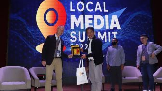 CEO PT Arkadia Digital Media Tbk/Pemimpin Redaksi Suara.com Suwarjono memberikan piagam ke pembicara IMS Head of Department Asia Lars Bestle usai seminar di acara Local Media Summit (LMS) 2022 di Perpustakaan Nasional RI,Jalan Medan Merdeka Selatan, Jakarta Pusat, Kamis (27/10/2022). [Suara.com/Alfian Winanto]