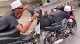 Tantang Malaikat Maut, Pria Ini Atraksi Tengkurap Naik Sepeda Motor Aksinya Tuai Kecaman