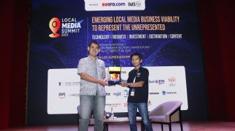 Redaktur Pelaksana Suara.com, Arsito Hidayatullah (kanan) memberikan piagam ke News Partnership Google Indonesia Yos Kusuma (kiri) saat menjadi pembicara workshop bertemakan "Business Ecosystem for Local Media Publisher" pada acara Local Media Summit 2022, di Gedung Perpusnas RI, Jalan Merdeka Selatan, Jakarta Pusat, Jumat (28/10/2022). [Suara.com/Alfian Winanto]