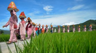 Ibu-ibu menjunjung jamba (makanan) saat mengikuti arak-arakan, pada Festival Galundi Singkarak di Nagari Batu Taba, Kabupaten Tanah Datar, Sumatera Barat, Sabtu (29/10/2022).  ANTARA FOTO/Iggoy el Fitra
