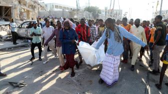 Warga membawa jenazah korban tewas setelah sebuah bom mobil meledak di Mogadishu, Somalia, Minggu (30/10/2022). [HASSAN ALI ELMI / AFP]
