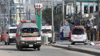 Personel keamanan dan ambulans ditempatkan di dekat bangunan yang hancur dan rusak setelah sebuah bom mobil meledak di Mogadishu, Somalia, Minggu (30/10/2022). [HASSAN ALI ELMI / AFP]