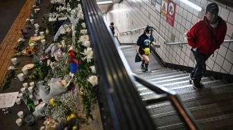 Karangan bunga sebagai penghormatan kepada para korban dalam tragedi Itaewon di luar stasiun kereta bawah tanah Itaewon, Seoul, Korea Selatan, Minggu (30/10/2022). [Anthony WALLACE / AFP]