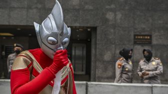 Aktivis lingkungan hidup Walhi berunjuk rasa di depan Kantor Kedutaan Besar Jepang, Jakarta, Selasa (1/11/2022). Salah satu dari mereka menggunakan kostum Ultraman. [ANTARA FOTO/Galih Pradipta/rwa].