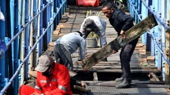 Pekerja memperbaiki Jembatan Ledeng di Kota Bogor, Jawa Barat, Selasa (1/11/2022). Jembatan ini telah berusia ratusan tahun dan dibangun pada jaman Belanda di atas Sungai Cisadane. [ANTARA FOTO/Arif Firmansyah/rwa].