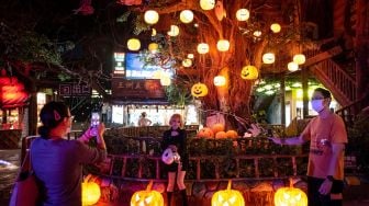 Orang-orang dengan kostum mengambil bagian dalam perayaan Halloween di Guangzhou, provinsi Guangdong selatan, China, Minggu (30/10/2022). [AFP / China OUT]