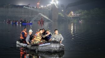 Personel penyelamat melakukan operasi pencarian setelah jembatan di seberang sungai Machchhu runtuh di Morbi, Ahmedabad, India, Senin (31/10/2022). [Sam PANTHAKY / AFP]