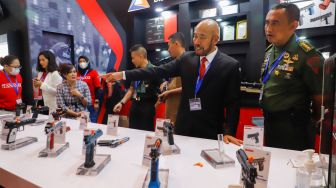 Pengunjung melihat beragam senjata api jenis handgun dalam perhelatan pameran industri pertahanan Indo Defence 2022 Expo & Forum di Jakarta International Expo (JIExpo), Kemayoran, Jakarta Pusat, Rabu (2/11/2022). [Suara.com/Alfian Winanto]