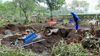 Warga mencari makam keluarganya yang hilang tersapu banjir di TPU Embah Besar, Desa Krikilan, Glenmore, Banyuwangi, Jawa Timur, Jumat (4/11/2022).  ANTARA FOTO/Budi Candra Setya