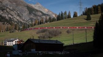 Penampakan kereta api sepanjang 1910 meter dengan 100 gerbong saat melintas di dekat Bergun, Swiss, Sabtu (29/10/2022). [Fabrice COFFRINI / AFP]