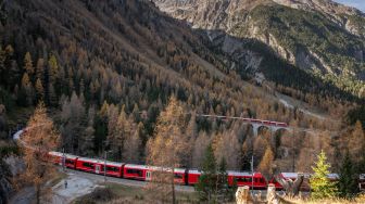 Penampakan kereta api sepanjang 1910 meter dengan 100 gerbong saat melintas di dekat Bergun, Swiss, Sabtu (29/10/2022). [Fabrice COFFRINI / AFP]