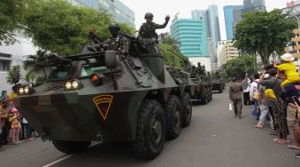 Warga menyaksikan konvoi kendaraan tempur saat Parade Surabaya Juang di Surabaya, Jawa Timur, Minggu (6/11/2022). [ANTARA FOTO/Didik Suhartono/foc]
