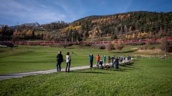 Penampakan kereta api sepanjang 1910 meter dengan 100 gerbong saat melintas di dekat Bergun, Swiss, Sabtu (29/10/2022). [Fabrice COFFRINI / AFP]