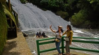 Pengunjung berswafoto di objek wisata alam Bantimurung yang berada di dalam kawasan Geopark Maros-Pagkep di Kabupaten Maros, Sulawesi Selatan, Sabtu (5/11/2022). [ANTARA FOTO/Arnas Padda/YU]
