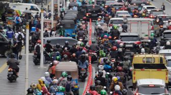 Sejumlah kendaraan bermotor menaiki trotoar saat melintas di Jalan Salemba Raya, Jakarta Pusat, Senin (7/11/2022). [Suara.com/Alfian Winanto]