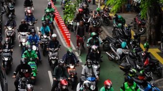 Pesepeda melintas di jalur sepeda bersama dengan kendaraan bermotor di Jalan Salemba Raya, Jakarta Pusat, Senin (7/11/2022). [Suara.com/Alfian Winanto]