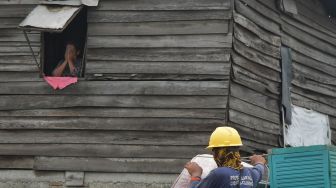 Petugas (kanan) memindahkan peralatan rumah warga yang terdampak pembebasan lahan proyek Jalan Tol CIbitung-CIlincing seksi 4 di Semper Timur, Cilincing, Jakarta Utara, Selasa (8/11/2022). [ANTARA FOTO/ Fakhri Hermansyah/aww].