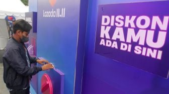 Pengunjung mencoba mesin diskon terbesar Festival belanja Lazada 11.11 Diskon Sebesar-besarnya di FX Sudirman, Jakarta. Selasa, (8/11/2022). [Suara.com/Oke Atmaja]