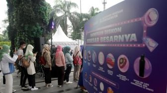 Pengunjung mengantre untuk mencoba mesin diskon terbesar Festival belanja Lazada 11.11 Diskon Sebesar-besarnya di FX Sudirman, Jakarta. Selasa, (8/11/2022). [Suara.com/Oke Atmaja]