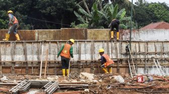 Pekerja menyelesaikan proses pembangunan underpass di Jalan Dewi Sartika, Depok, Jawa Barat, Rabu (9/11/2022). [Suara.com/Alfian Winanto]