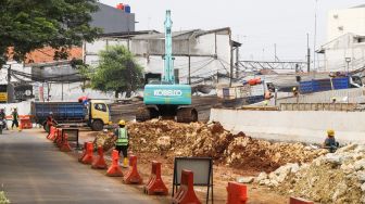 Pekerja menyelesaikan proses pembangunan underpass di Jalan Dewi Sartika, Depok, Jawa Barat, Rabu (9/11/2022). [Suara.com/Alfian Winanto]