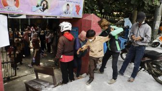 Sejumlah siswa berjalan keluar melintasi jalan darurat yang dibuat pihak orang tua murid di SDN Pondok Cina 1, Depok, Jawa Barat, Rabu (9/11/2022). [Suara.com/Alfian Winanto]