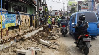 Pekerja menyelesaikan proyek revitalisasi trotoar di Jalan Dewi Sartika, Depok, Jawa barat, Rabu (9/11/2022). [Suara.com/Alfian Winanto]