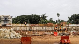 Pekerja menyelesaikan proses pembangunan underpass di Jalan Dewi Sartika, Depok, Jawa Barat, Rabu (9/11/2022). [Suara.com/Alfian Winanto]