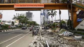 Warga berjalan di samping trotoar yang direvitalisasi di Jalan Margonda Raya, Depok, Jawa barat, Rabu (9/11/2022). [Suara.com/Alfian Winanto]