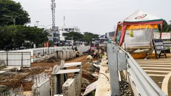 Pekerja menyelesaikan proses pembangunan underpass di Jalan Dewi Sartika, Depok, Jawa Barat, Rabu (9/11/2022). [Suara.com/Alfian Winanto]