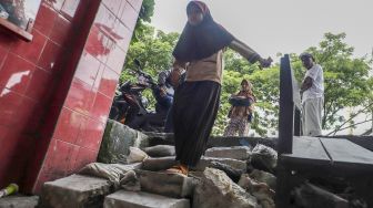 Sejumlah siswa berjalan melintasi jalan darurat yang dibuat pihak orang tua murid di SDN Pondok Cina 1, Depok, Jawa Barat, Rabu (9/11/2022). [Suara.com/Alfian Winanto]