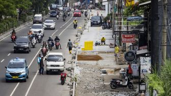 Warga berjalan di samping trotoar yang direvitalisasi di Jalan Margonda Raya, Depok, Jawa barat, Rabu (9/11/2022). [Suara.com/Alfian Winanto]