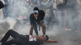 Suporter Arema FC (Aremania) melakukan aksi teatrikal saat berunjuk rasa memperingati 40 Hari Tragedi Kanjuruhan di jalan Basuki Rahmat, Malang, Jawa Timur, Kamis (10/11/2022). [ANTARA FOTO/H. Prabowo/abs/tom].