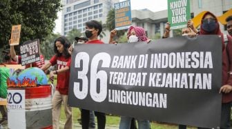 Sejumlah aktivis dari Wahana Lingkungan Hidup Indonesia (Walhi) menggelar aksi unjuk rasa di  depan Gedung Plaza Mandiri, Jakarta Selatan, Kamis (10/11/2022). [Suara.com/Alfian Winanto]