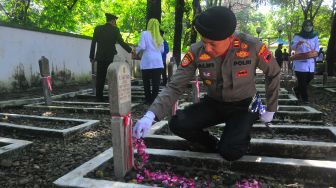 Anggota polisi menaburkan bunga saat ziarah di Makam Pahlawan Setya Pertiwi, Kudus, Jawa Tengah, Kamis (10/11/2022). [ANTARA FOTO/Yusuf Nugroho/tom].