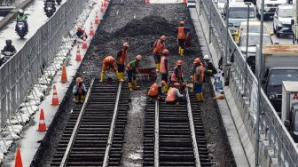 Pekerja melakukan pembongkaran aspal yang menutup jalur trem pada masa kolonial Belanda di lokasi proyek MRT Jakarta fase 2 di kawasan Jalan Gajah Mada, Jakarta Pusat, Kamis (10/11/2022). [Suara.com/Alfian Winanto]